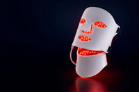Mascarilla facial LED con luz roja, foto de estudio en tono azul